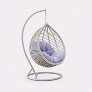 White hanging egg chair with cushioned seat and freestanding curved stand for garden patio and indoor seating